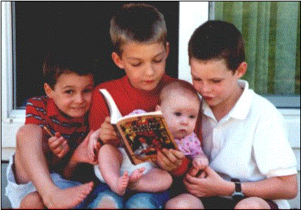 AMos, Josh, Irene, and Beni sharing a book. Photo by Paula Wilson.